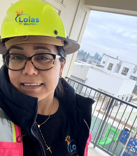 Lola's Shiny Solutions team member wearing hard hat on job site balcony