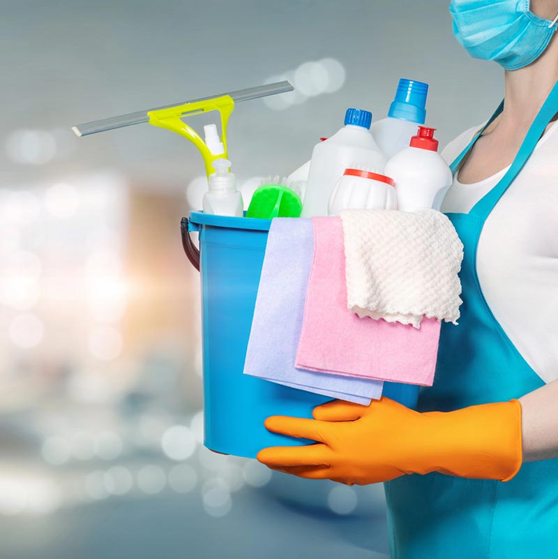 Cleaning professional holding bucket of janitorial supplies