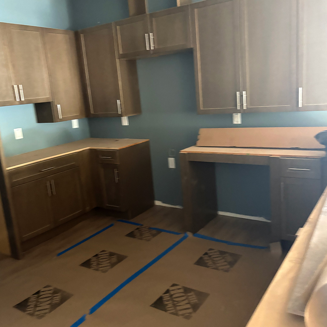 post_construction_lolas-shiny-2 Newly installed kitchen cabinets with protective floor covering before final cleaning